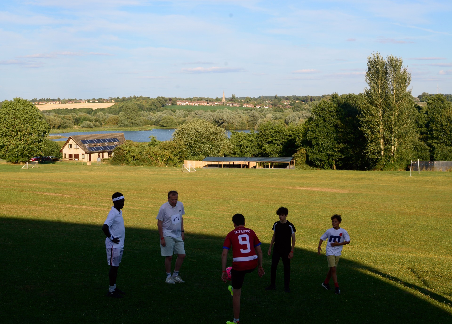 Campers playing football with the site in the background.